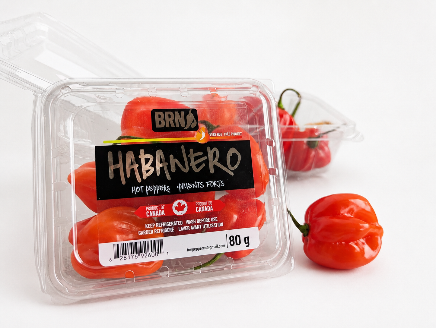 BRN Habanero peppers in an 80 gram clamshell pack on a wooden crate
